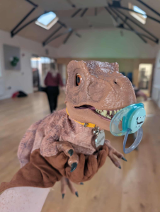 Animatronic baby dino t rex holding a dummy