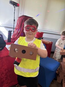Child in high vis vest holding a brick at a builder themed party